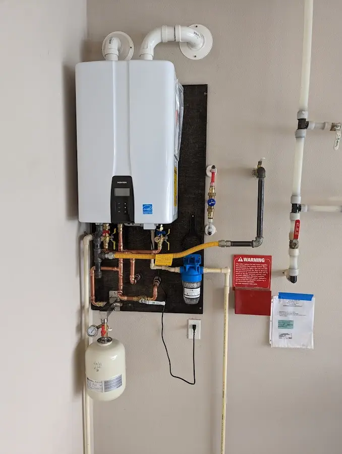Professional plumber installing copper piping in a Scriba home